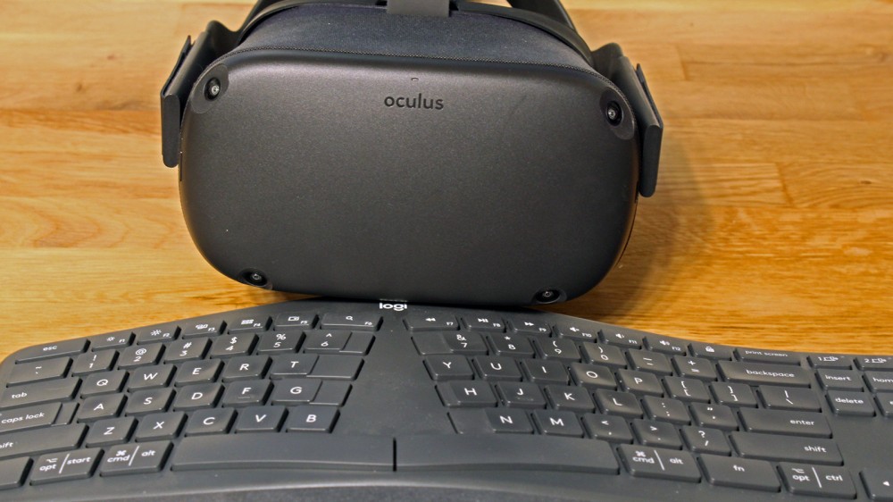An Oculus Quest in front of a Logitech keyboard