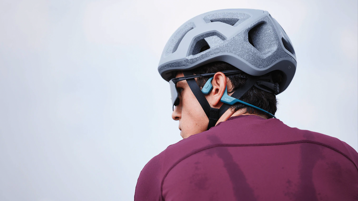 A cyclist wearing a pair of bone conduction headphones.