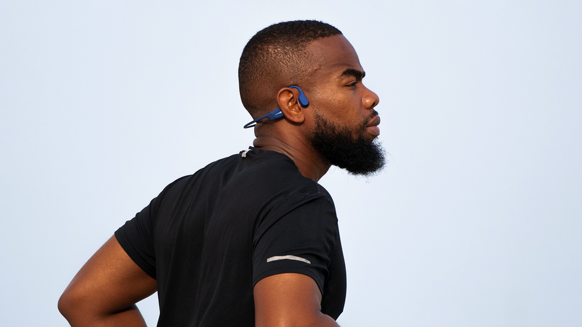 A runner wearing a pair of bone conduction headphones.