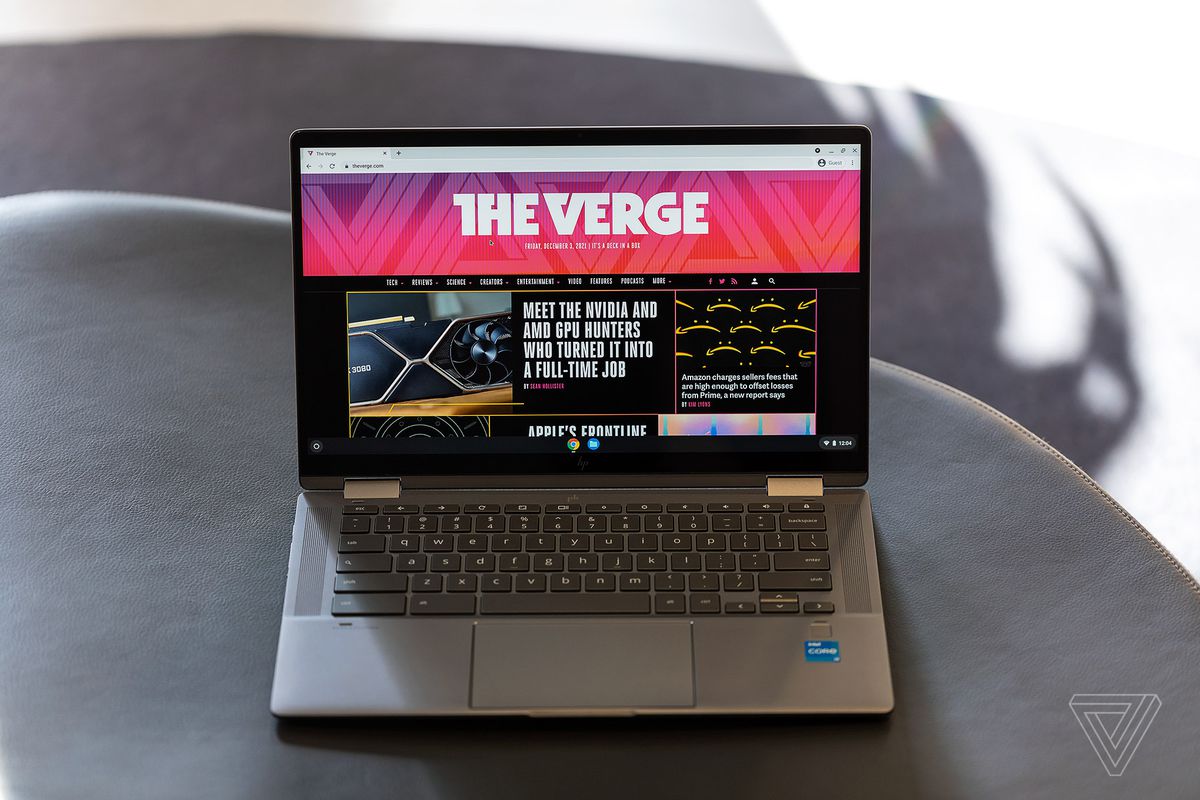 The HP Chromebook x360 14c open seen from above on a gray table. The screen displays The Verge homepage.