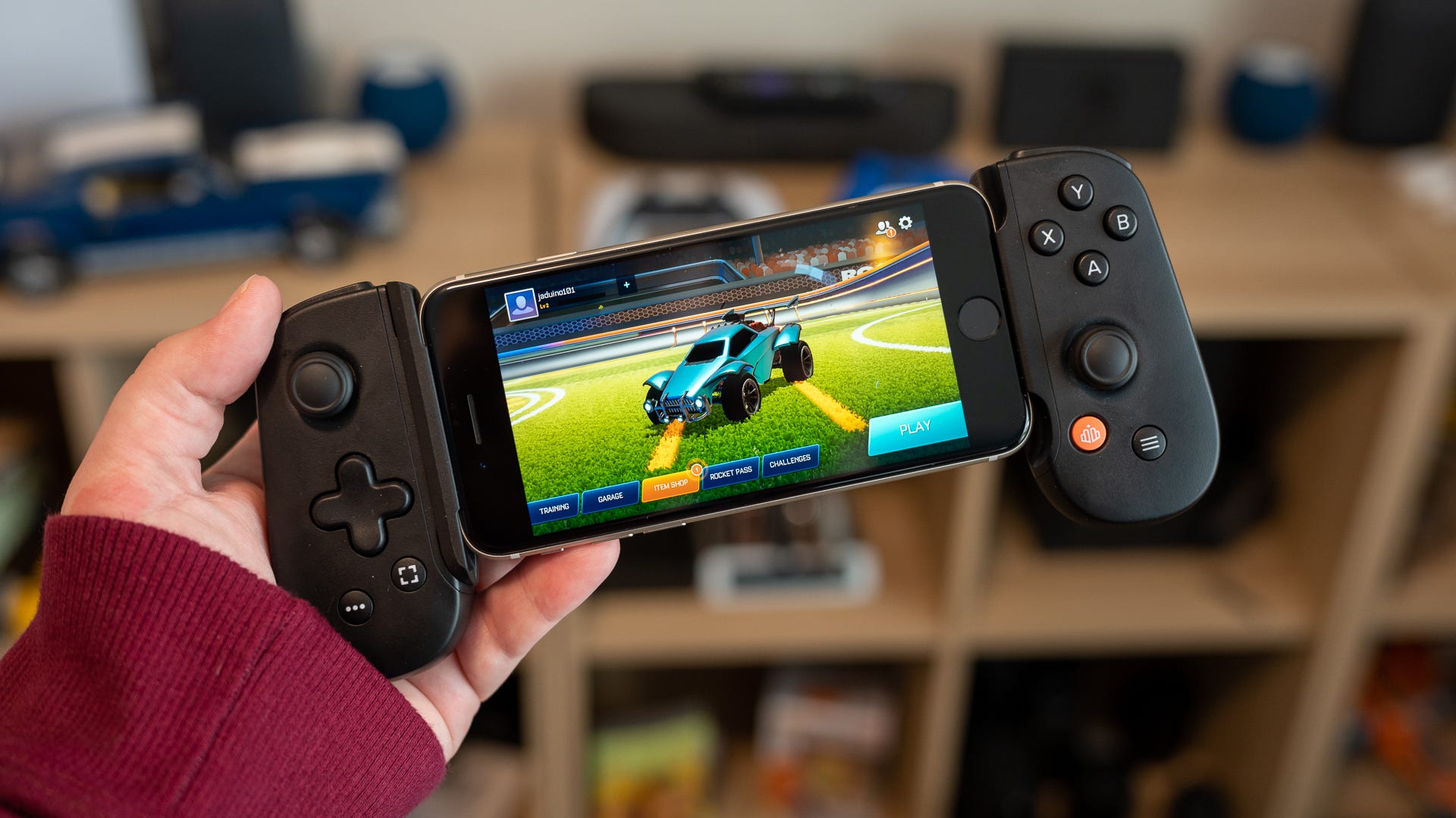 Person playing a video game using the Backbone controller attached to an iPhone
