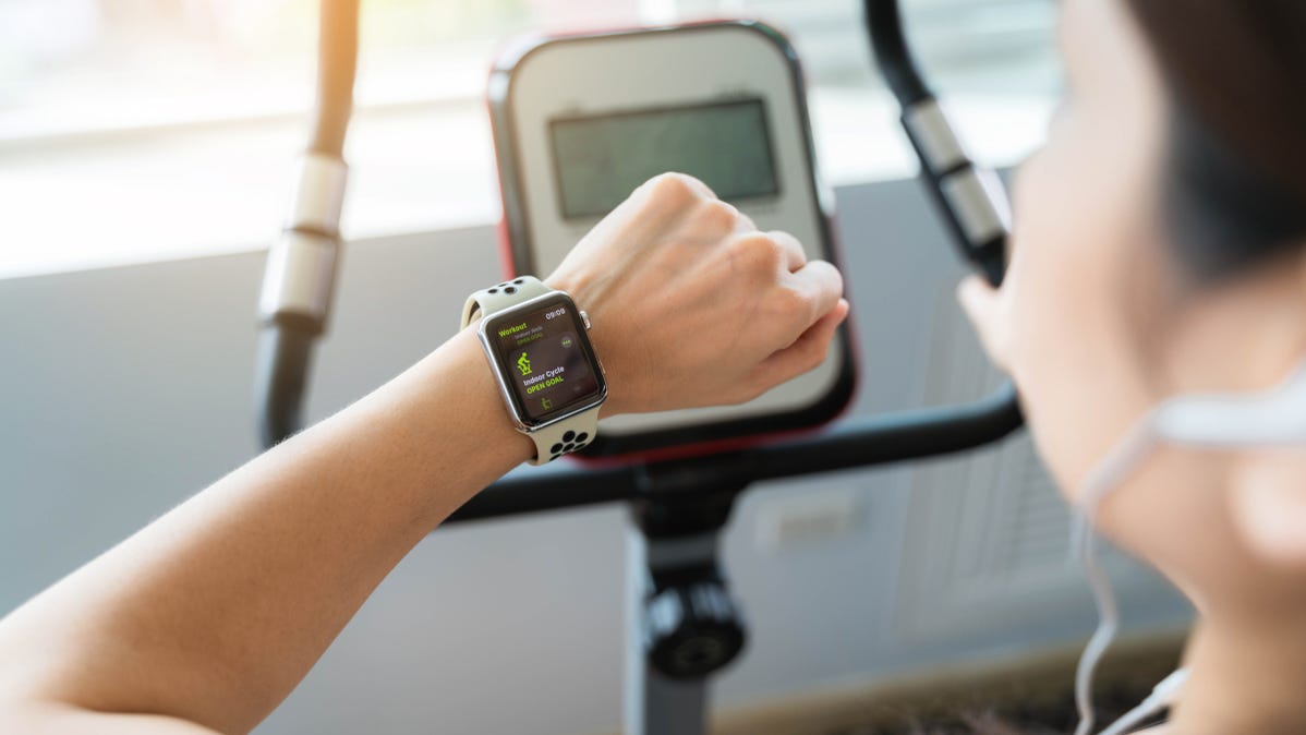 Apple Watch on the arm of a woman working out at a gym.