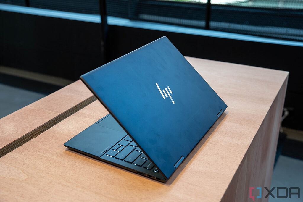 PArtially open blue HP Envy x360 13 on wooden table