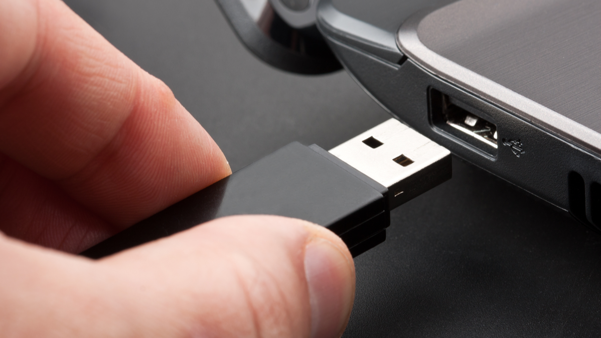 USB flash drive into USB port on laptop header image.