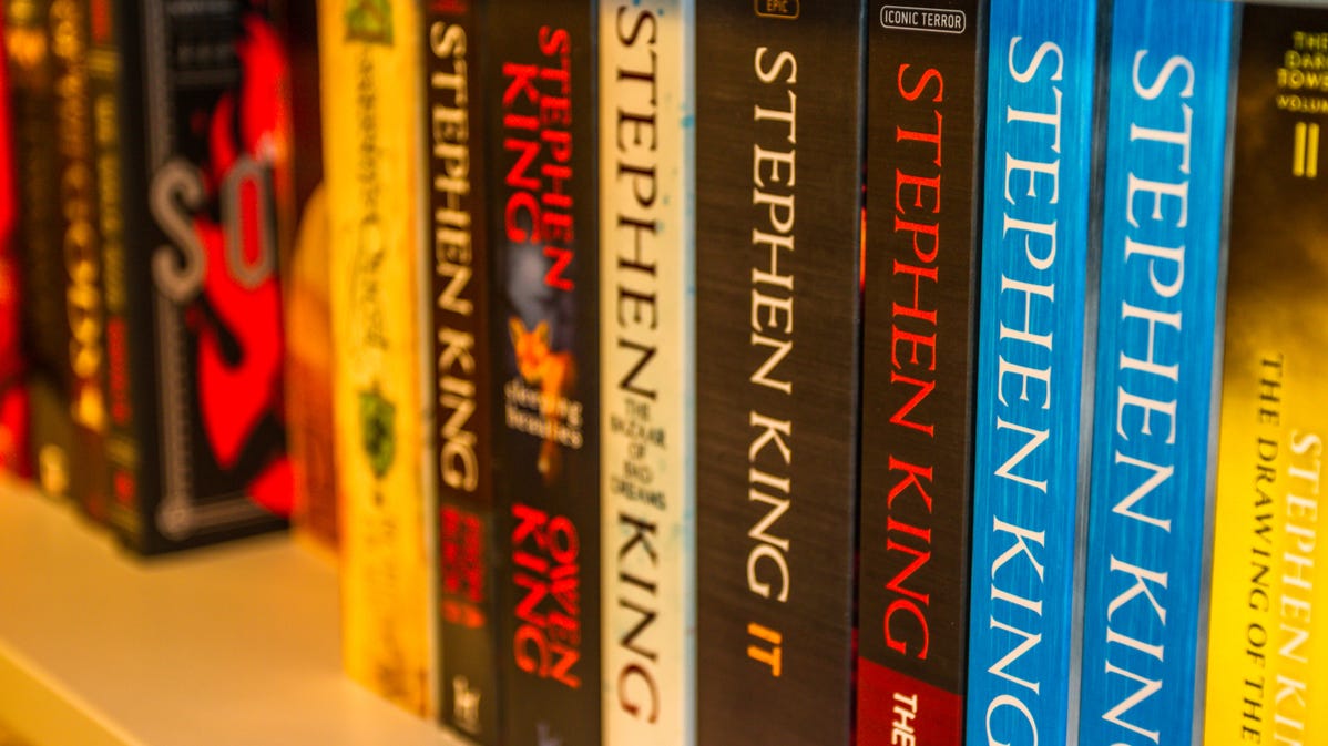 A collection of Stephen King paperback books on a shelf.