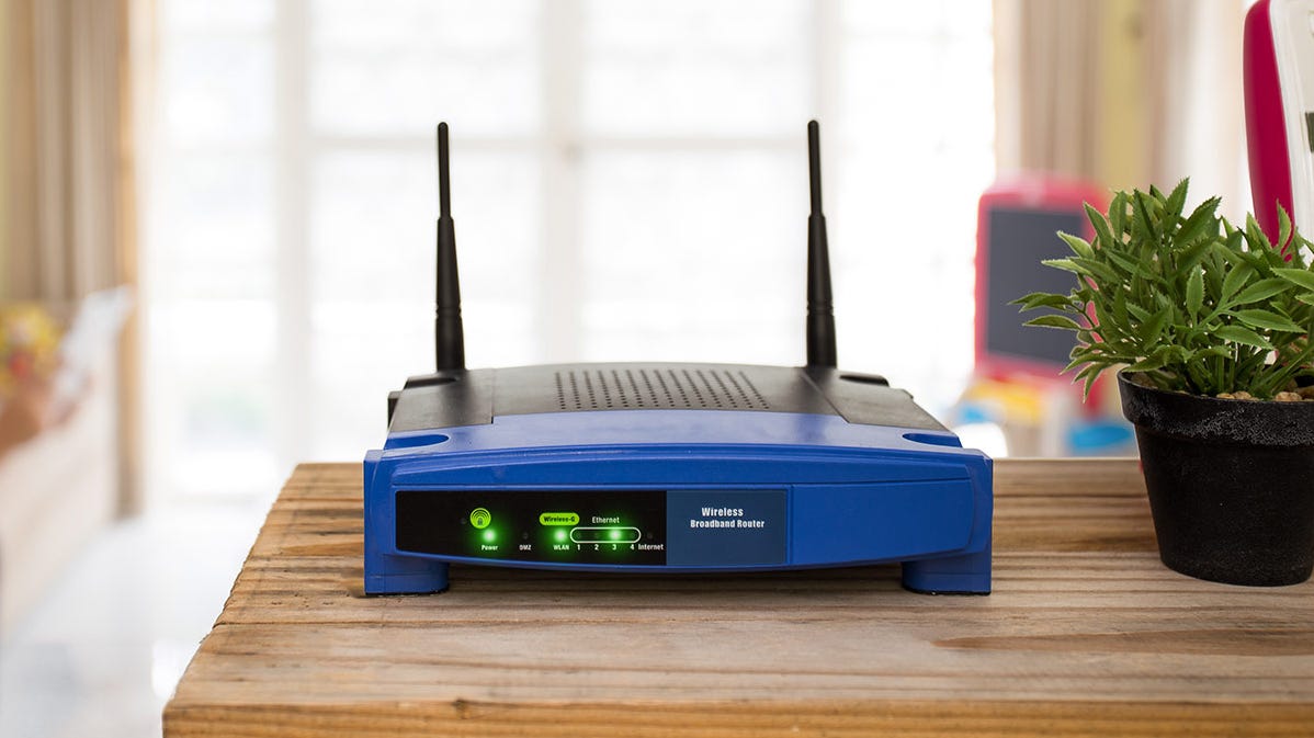 An old Linksys router sitting on a living room table.