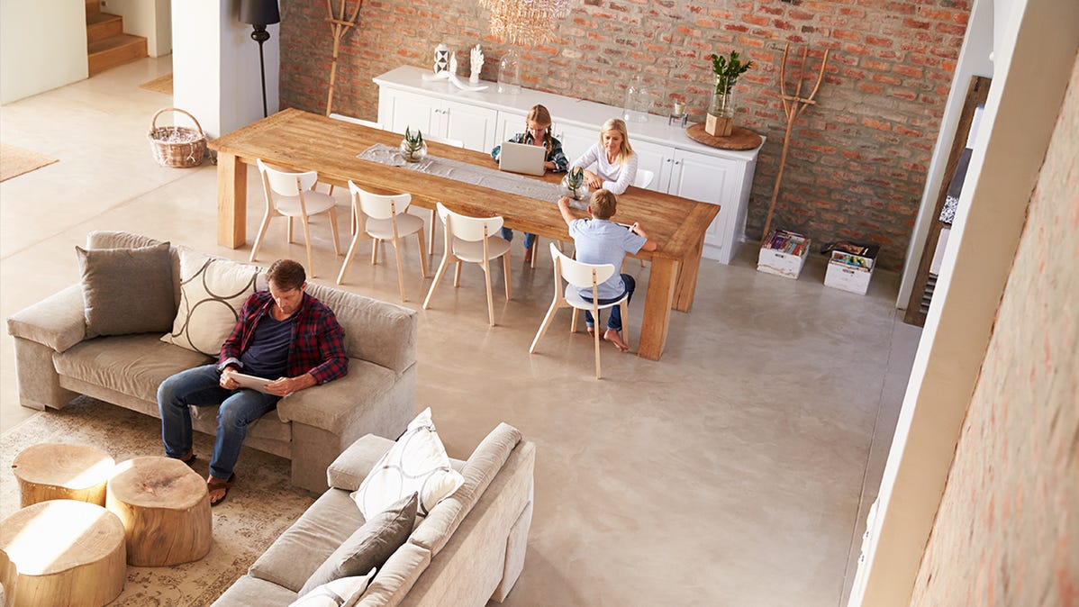 A family in an open concept living space, using tablets and other Wi-Fi devices.