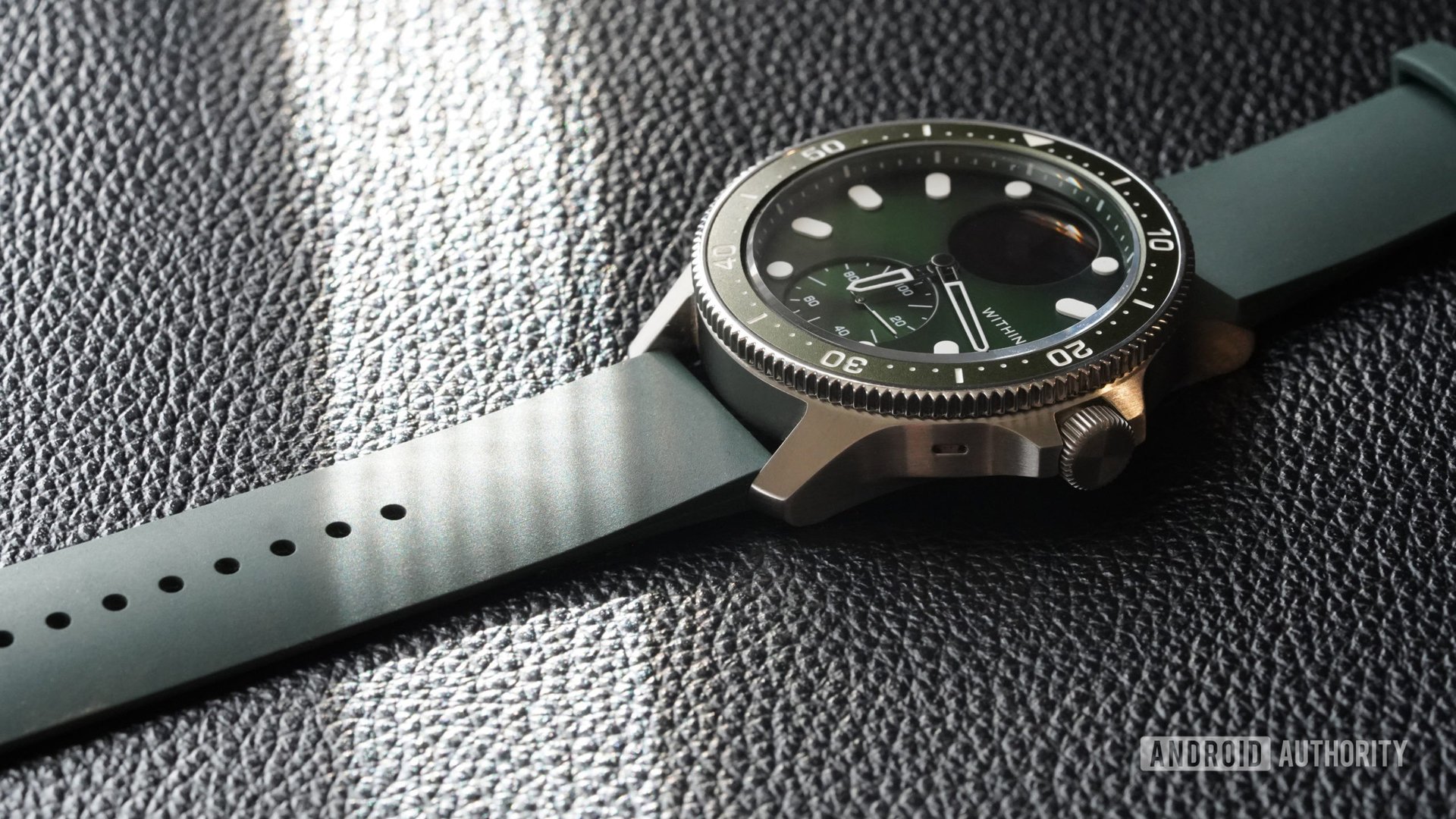 A Withings ScanWatch Horizon in Green rests on a black leather surface.