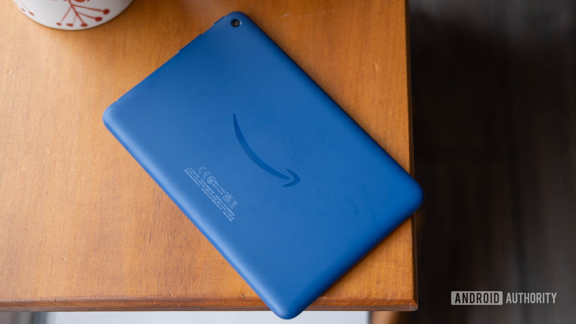 The amazon fire 7 2022 lies on a table showing the rear of the tablet 
