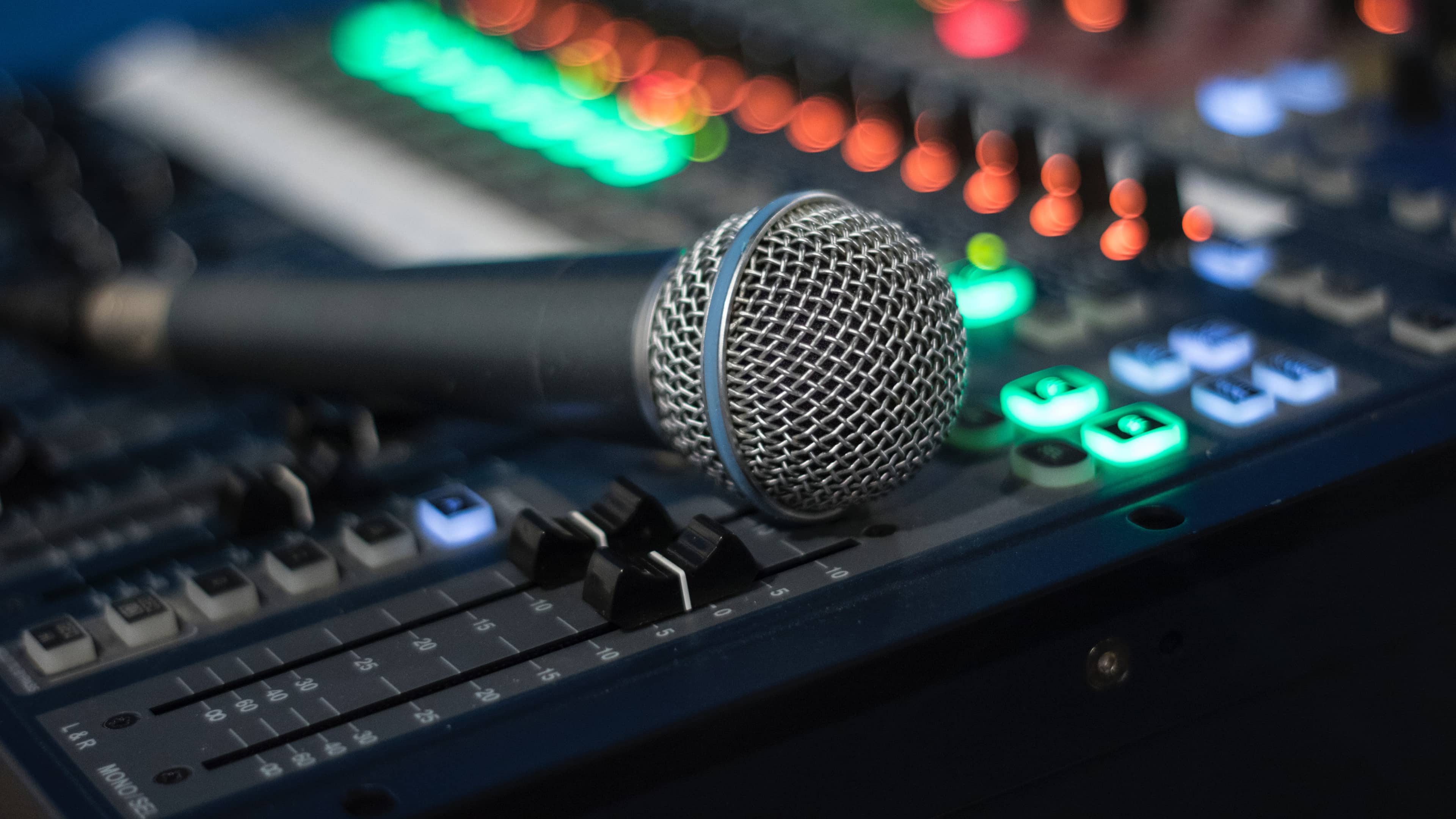 Closeup of a studio microphone laying on a mixing console